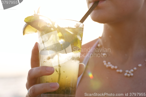 Image of Woman enjoying a tropical mojito cocktail