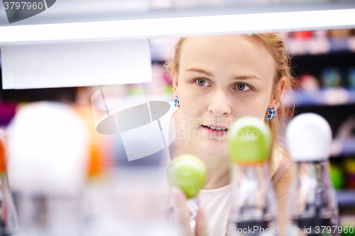 Image of Young woman analyzing products in a store