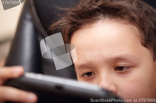 Image of Boy tired of playing his portable game console.