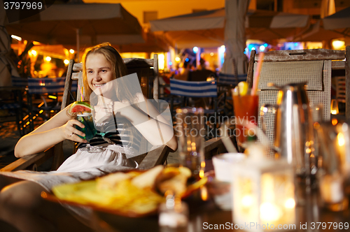 Image of Smiling woman drinking in a cafeteria