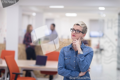 Image of portrait of young business woman at office with team in backgrou