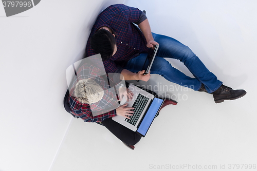 Image of top view of  couple working on laptop computer at startup office