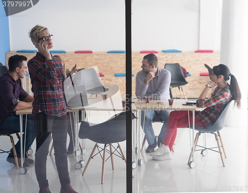 Image of business woman in meeting room  speaking by cell phone