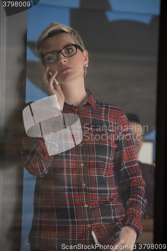 Image of business woman in meeting room  speaking by cell phone
