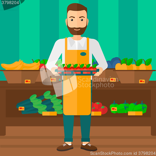 Image of Supermarket worker with box full of apples.