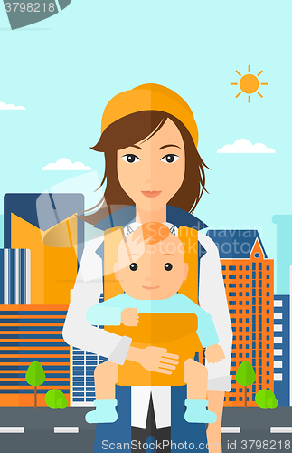 Image of Woman holding baby in sling.