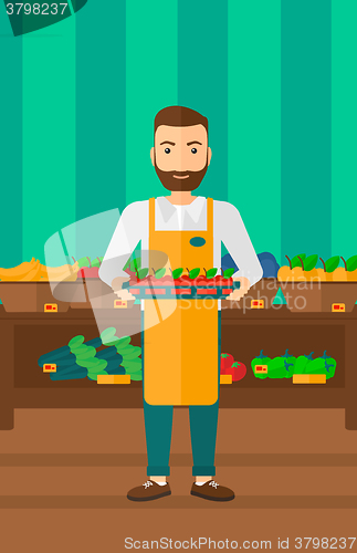 Image of Supermarket worker with box full of apples.