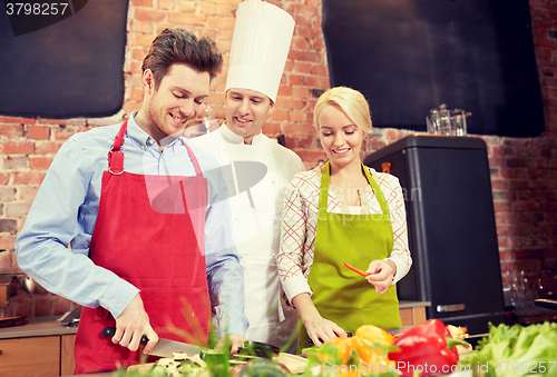 Image of happy couple and male chef cook cooking in kitchen