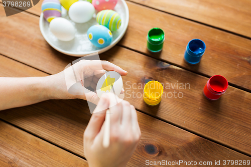 Image of close up of woman hands coloring easter eggs