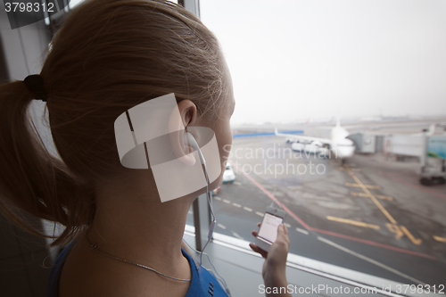 Image of Woman in headphones looking at aiport area