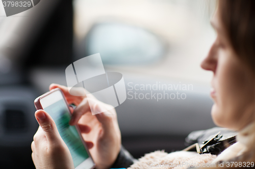 Image of Woman uses smartphone in the car