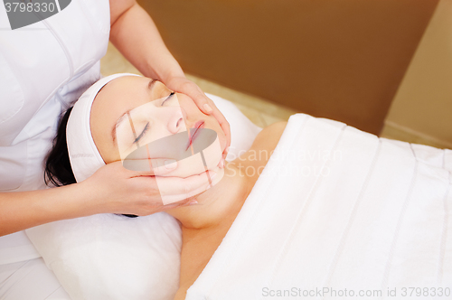 Image of Woman taking facial treatments at beauty spa