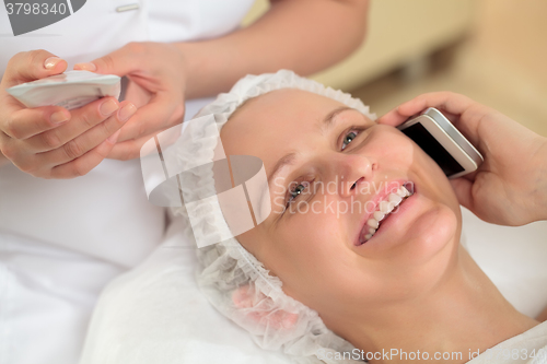 Image of Woman having a phone talk at beauty spa