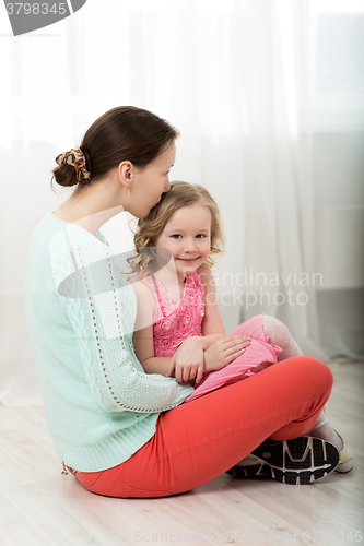 Image of Mother kissing dear little daughter