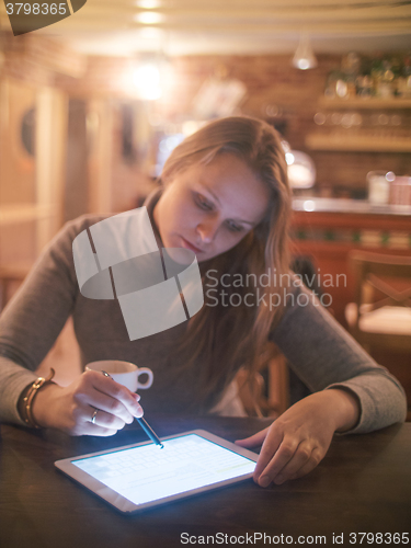 Image of Woman with Tablet PC and Stylus in Cafe