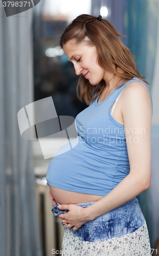 Image of Pregnant woman stands in the room