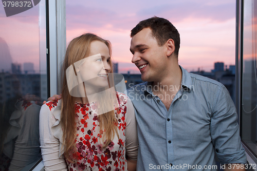 Image of Young couple on the balcony looking to each other