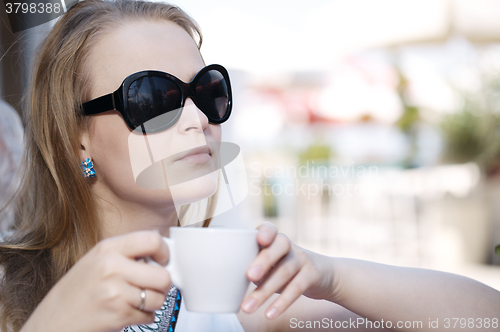 Image of Young woman drinking coffee