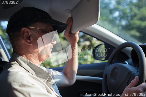 Image of Senior driver hiding from the sun