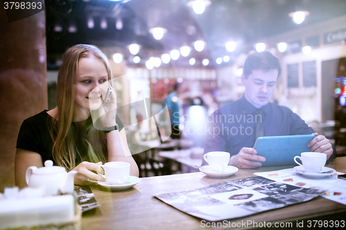 Image of Woman on cellphone drinking coffee