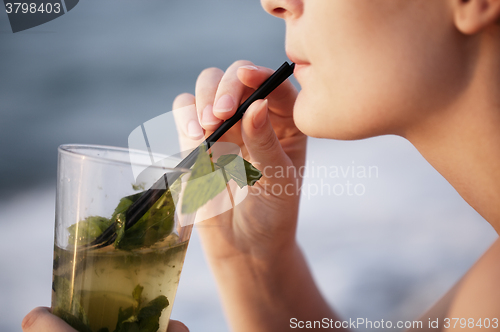 Image of Close up of woman enjoying an evening cocktail