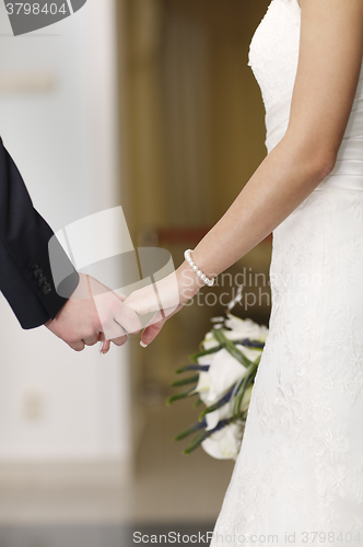 Image of Bride and groom holding hands