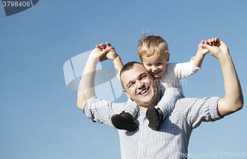 Image of Dad giving his young son a piggy back ride