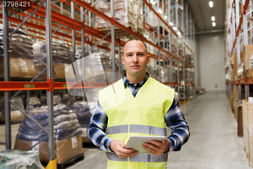 Image of manual worker with tablet pc at warehouse