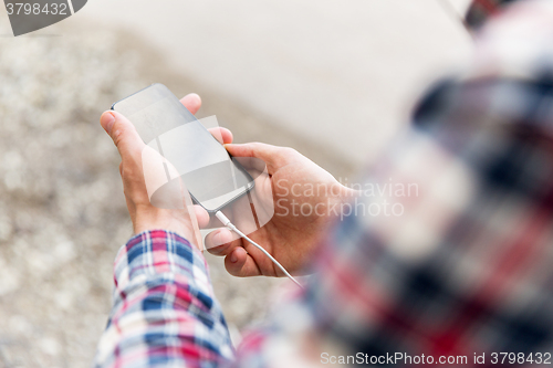 Image of close up of male hands with smartphone on street