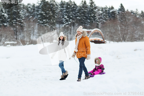 Image of happy family with sled walking in winter forest