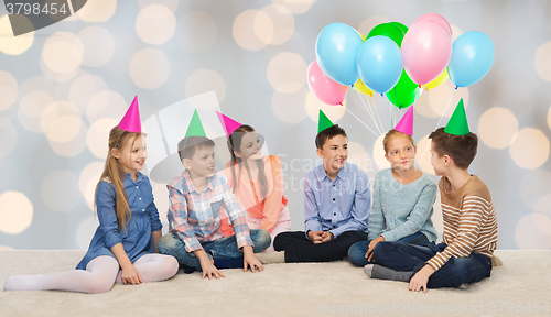 Image of happy smiling children in party hats on birthday