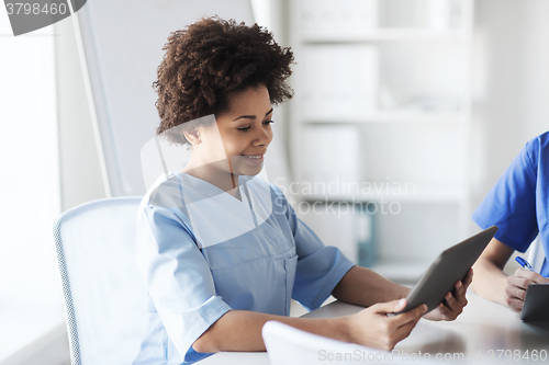 Image of happy female doctor or nurse with tablet pc
