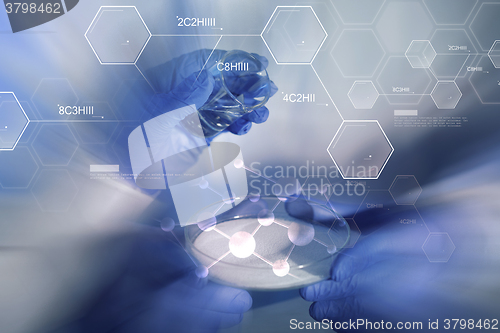 Image of close up of scientists hands with chemicals in lab