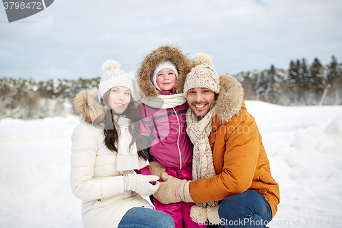 Image of happy family with child in winter clothes outdoors