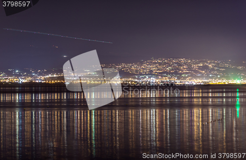 Image of Light streak in sky over city at night