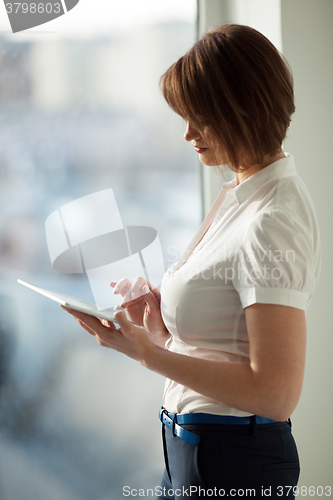 Image of Side view of adult woman using tablet 