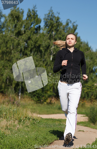 Image of Girl running in the park. Wide shot