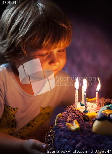 Image of Little boy blows out candles on his birthday