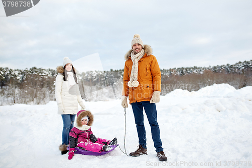 Image of happy family with sled walking in winter outdoors