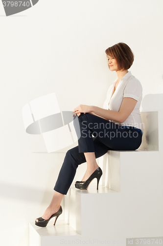 Image of Relaxed businesswoman sitting on stairs with eyes closed