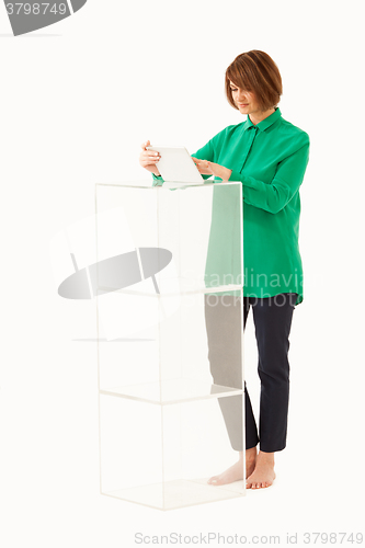 Image of Adult woman using tablet near glass stand