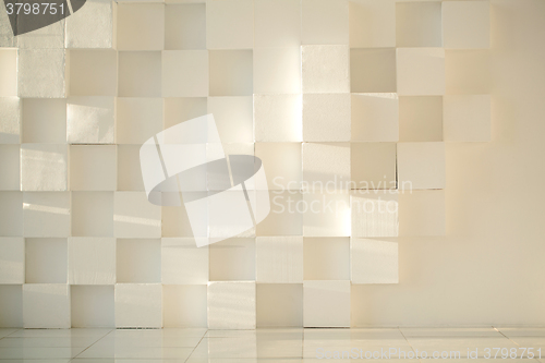 Image of White painted concrete wall made of cubes with tiled floor