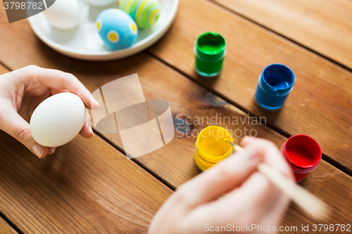 Image of close up of woman hands coloring easter eggs