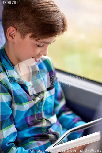Image of happy boy with tablet pc in travel bus or train
