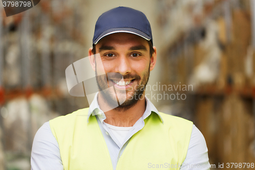 Image of happy man in reflective safety vest at warehouse