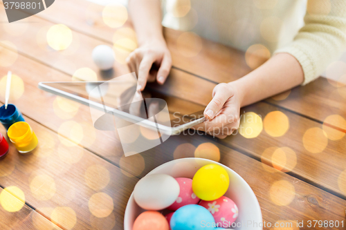 Image of close up of woman with tablet pc and easter eggs