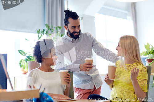 Image of happy creative team drinking coffee in office