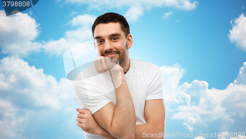 Image of smiling man over blue sky