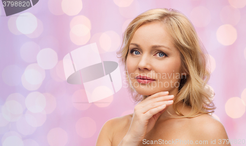 Image of woman with bare shoulders touching face