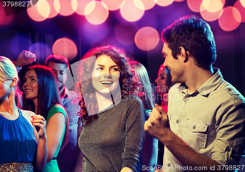 Image of smiling friends dancing in club